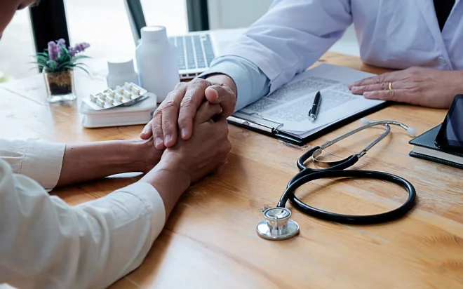 Person füllt Formulare aus, um die Krankenkasse zu wechseln