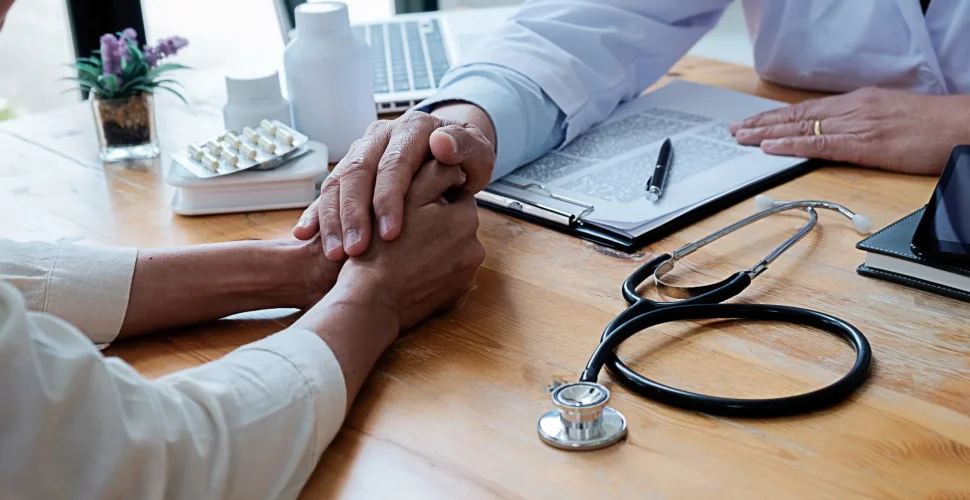 Person füllt Formulare aus, um die Krankenkasse zu wechseln